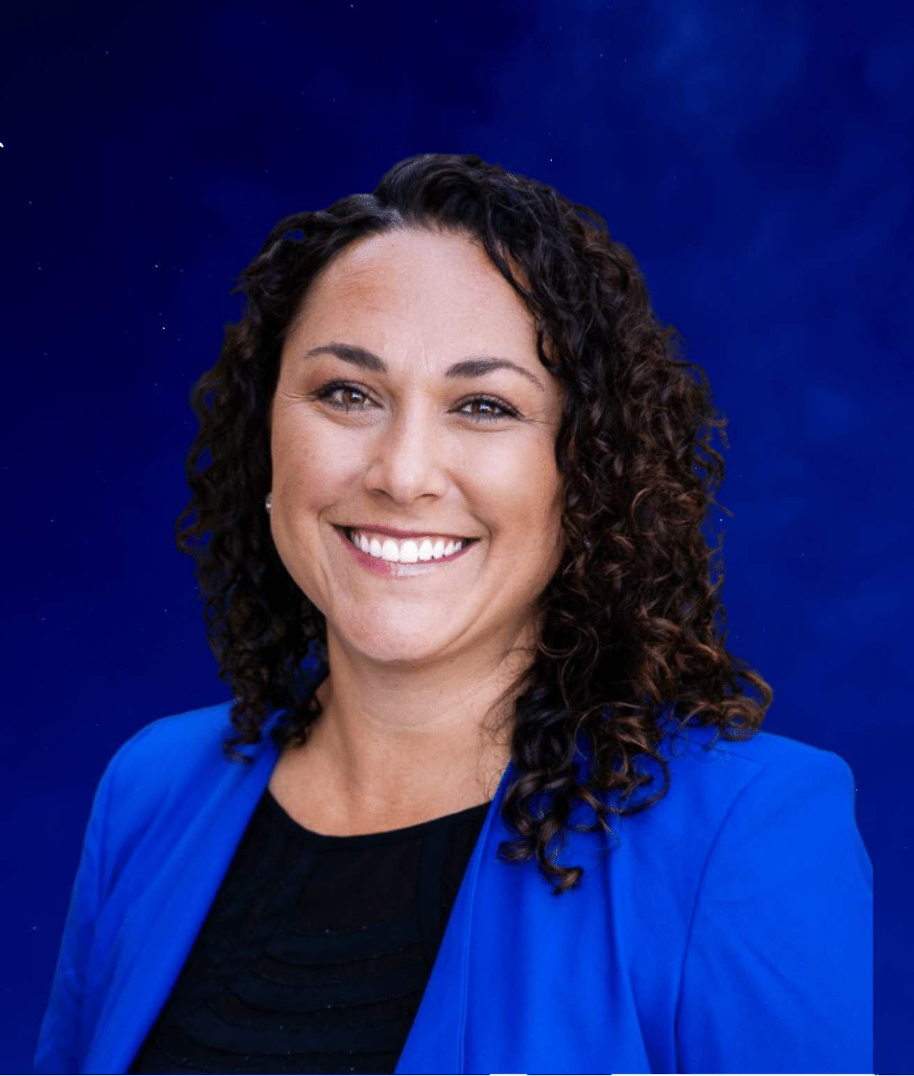 Katy, a smiling woman with dark curly hair and a blue blazer